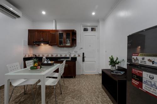 a kitchen with a table and chairs and a kitchen with a tv at 그레이스 호텔 Grace Hotel & Residence in Hanoi
