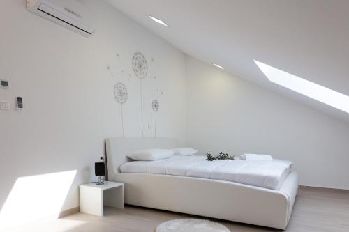 a white bedroom with a white bed in a attic at Apartment Alius Ragusa Deluxe in Dubrovnik