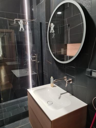 a bathroom with a sink and a mirror at Apartamenty Osmolice w Stawach in Dęblin