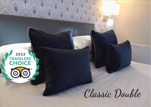 a bedroom with a black and white bed with black pillows at Allerdale Court Hotel in Cockermouth