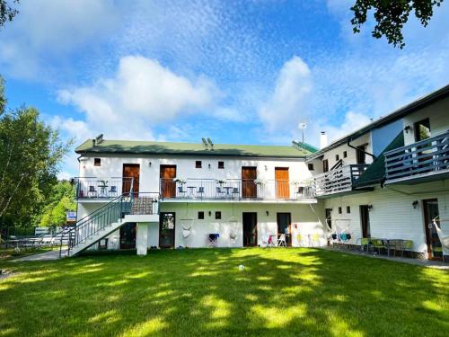 a large white building with a lawn in front of it at Brzozowa Oaza in Mrzeżyno