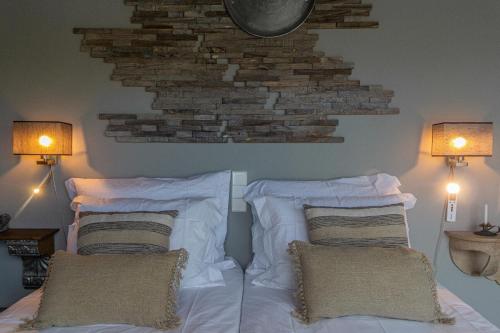 a bedroom with two beds with pillows and a brick wall at Villa Cerrado das Fontainhas SPA in Sintra