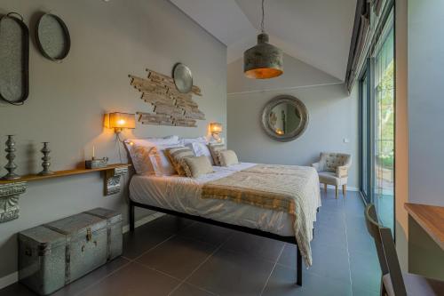 a bedroom with a bed and a chair and a window at Villa Cerrado das Fontainhas SPA in Sintra