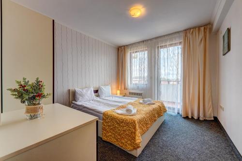 - une chambre avec un lit et une grande fenêtre dans l'établissement Colorful 2BD Apartment with Indoor Fireplace and Mountain View, à Pamporovo