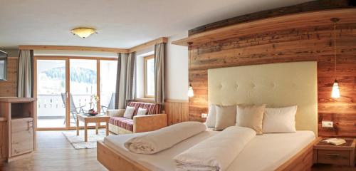 ヴィラ・オットーネにあるHotel Enzianの木製の壁のベッドルーム1室(大型ベッド1台付)