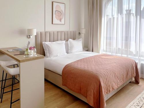 a bedroom with a bed and a desk and a window at Kurkowa Apartments in Szczecin