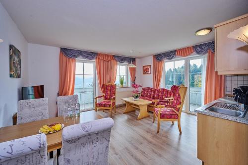 eine Küche und ein Wohnzimmer mit einem Tisch und Stühlen in der Unterkunft Richterhof Wellness Apartments Bayerischer Wald in Kollnburg