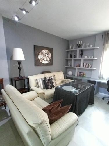 Cozy apartment & free parking في إشبيلية: غرفة معيشة مع أريكة بيضاء وطاولة