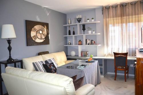 ein Wohnzimmer mit einem weißen Sofa und einem Tisch in der Unterkunft Cozy apartment & free parking in Sevilla