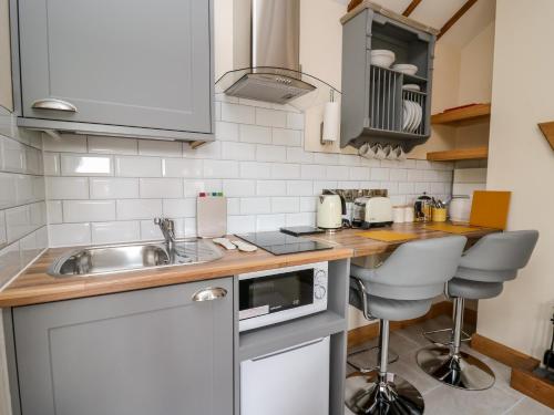 a small kitchen with a sink and a counter at The Old Cobblers Shop in Llandrindod Wells