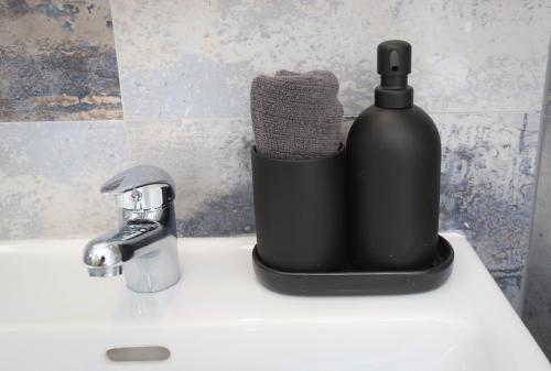a black soap dispenser sitting on top of a sink at Apartments Vienna Opera in Vienna