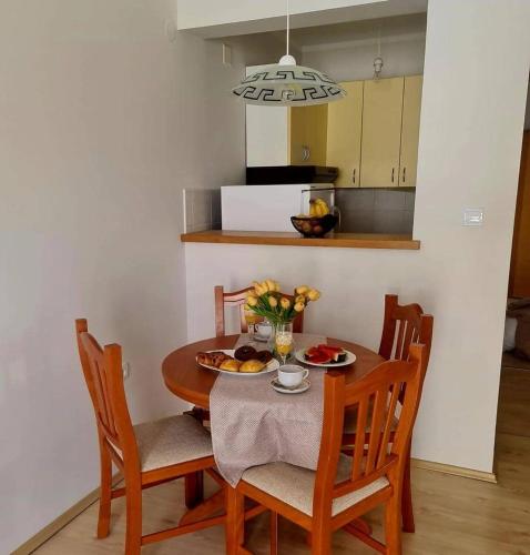 a kitchen with a table and chairs with a plate of food at Apartments MaRo in Pag