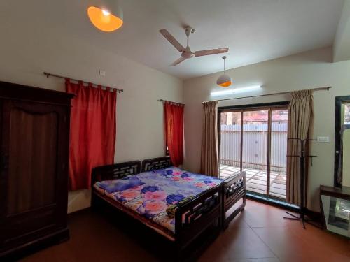 a bedroom with a bed and a large window at Nivritti Villa in Matheran