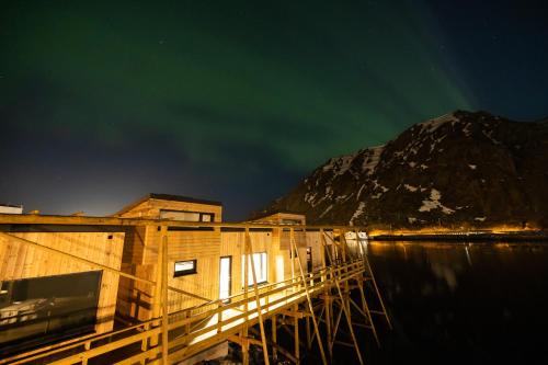 a building on a dock in the water at night at Hemmingodden Lodge in Ballstad