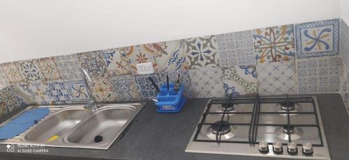 a kitchen with two sinks and tiles on the wall at Villa adriana in Pantelleria
