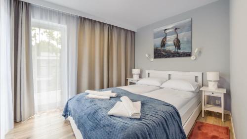 sypialnia z łóżkiem z dwoma białymi butami w obiekcie Apartamenty Sun & Snow Baltic Apartments z basenem w Pobierowie