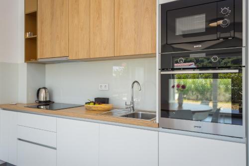 cocina con fregadero y microondas en Apartments at Villa Frida, en Premantura