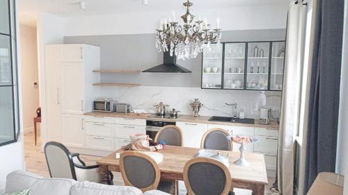 a kitchen with a wooden table and a chandelier at Bea Garden Home - dwie sypialnie i taras in Elblag