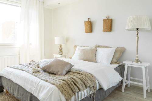 Parvekkeellinen kaksio Tammelan Torin laidalla في تامبير: غرفة نوم بيضاء مع سرير مع بطانية