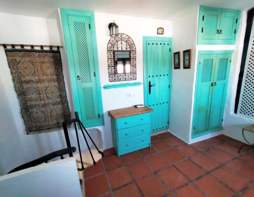 a room with turquoise cabinets and a table at El Cobijo de Vejer in Vejer de la Frontera