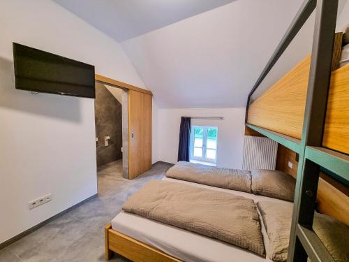 a bedroom with two bunk beds and a flat screen tv at Rackésmillen in Enscherange