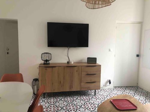 ein Wohnzimmer mit einem Flachbild-TV an der Wand in der Unterkunft Jolie maison de pêcheur ARAGO aux Sables d'Olonne in Les Sables-dʼOlonne