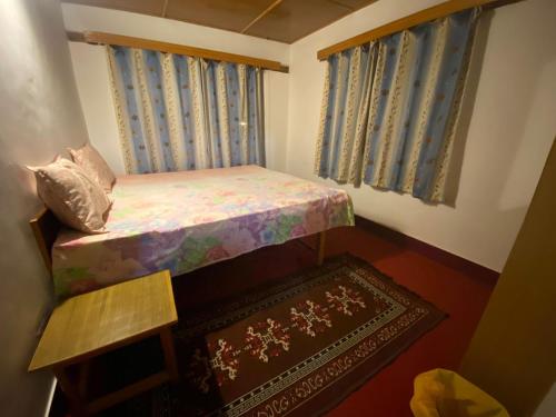 a small bedroom with a small bed and a rug at Gomang guest house Leh in Leh