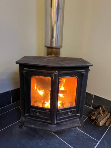 a stove that is sitting on a tiled floor at The Billiard Room - Cosy Country Retreat in Abergavenny