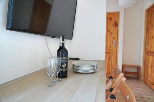 una botella de vino sentada en una mesa con copas en Niebieskie Lato Mieroszyno, en Jastrzębia Góra