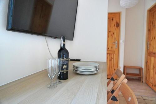 a bottle of wine sitting on a table with glasses at Niebieskie Lato - Mieroszyno w pobliżu Jastrzębiej Góry in Jastrzębia Góra