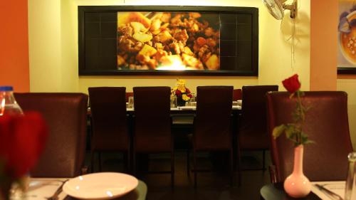 a restaurant with a table with chairs and a painting on the wall at Hotel Chennai Gate in Chennai