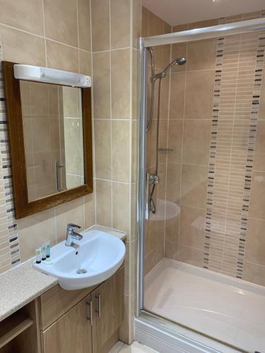 y baño con lavabo y ducha. en The Barrington Arms Hotel, en Shrivenham