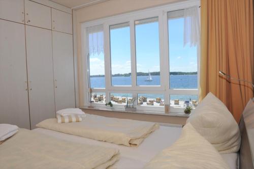 1 Schlafzimmer mit 2 Betten und einem großen Fenster in der Unterkunft Strandhotel 26 in Laboe