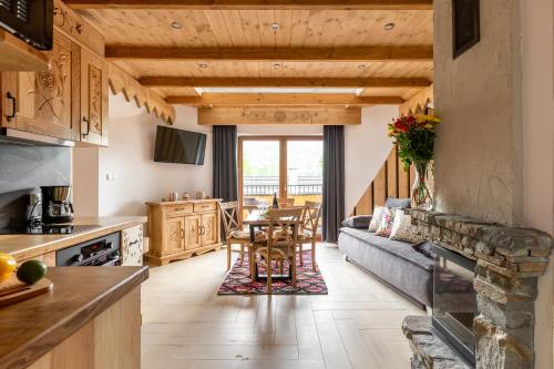 a kitchen and living room with a couch and a table at Aparthotel Delta Royal in Kościelisko