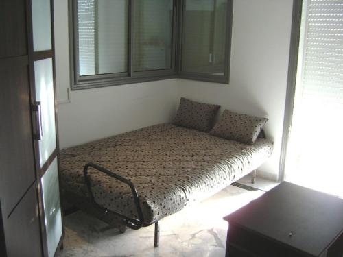 - un lit dans l'angle de la chambre dans l'établissement Studio Résidence Neptune Sousse Zone Kantaoui, à Port El-Kantaoui