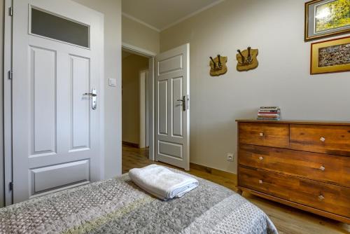 a bedroom with a bed and a wooden dresser at Rentynówka in Gietrzwałd