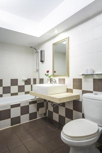a bathroom with a toilet and a sink and a tub at MILORD BOUTIQUE HOTEL in Kaohsiung