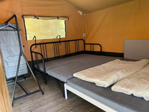 a bedroom with two bunk beds in a tent at 'Glamping' Angelzelt am See mit Steg und Boot (Mecklenburger Seenplatte) in Blankensee