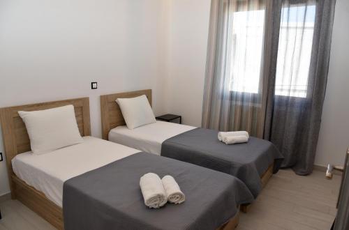Un dormitorio con dos camas con toallas encima. en STELLA'S LUXURY HOUSE, en Batsi