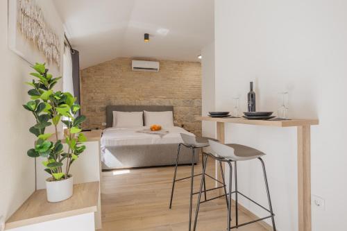 um quarto com uma cama, uma mesa e bancos em Apartments Piritus em Split