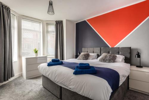 a bedroom with a large bed with blue towels on it at Hopetown Apartment-modern 1 bed with free parking in Normanton