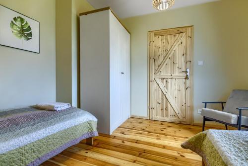 a room with two beds and a sliding door at Rentynówka in Gietrzwałd
