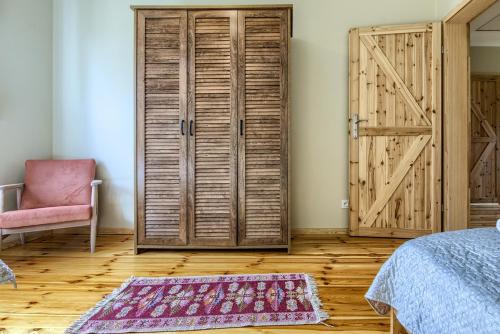 a bedroom with a closet and a door and a rug at Rentynówka in Gietrzwałd