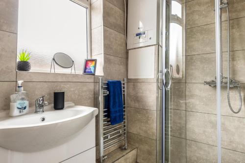 ein Bad mit einem Waschbecken und einer Dusche in der Unterkunft Hopetown Apartment-modern 1 bed with free parking in Normanton
