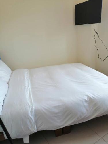 a white bed in a room with a tv on the wall at mei hao min su in Nangan