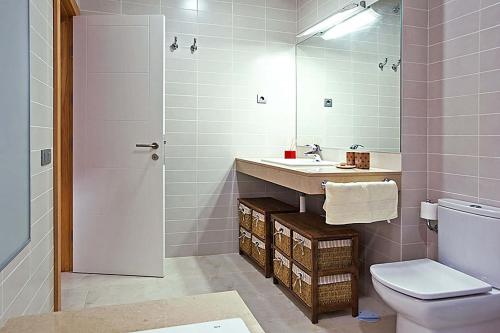 bagno con lavandino, servizi igienici e specchio di Salobre Vista Golf 28 a Maspalomas