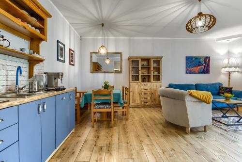 a kitchen with blue cabinets and a living room at Rentynówka in Gietrzwałd