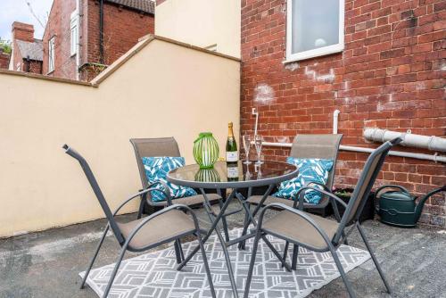 einen Tisch mit 4 Stühlen und eine Flasche Wein in der Unterkunft Hopetown Apartment-modern 1 bed with free parking in Normanton