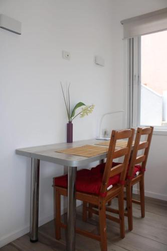 a dining room table with two chairs and a potted plant at Zimmer Ba'Ir in Kefar Sava