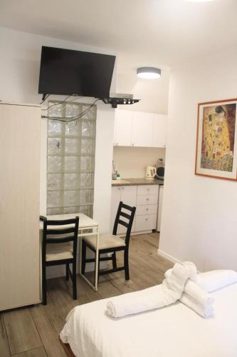 a room with a table and chairs and a kitchen at Zimmer Ba'Ir in Kefar Sava